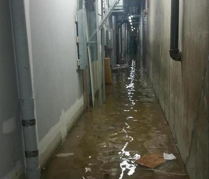 brown, dirty water covering the hallway of a warehouse