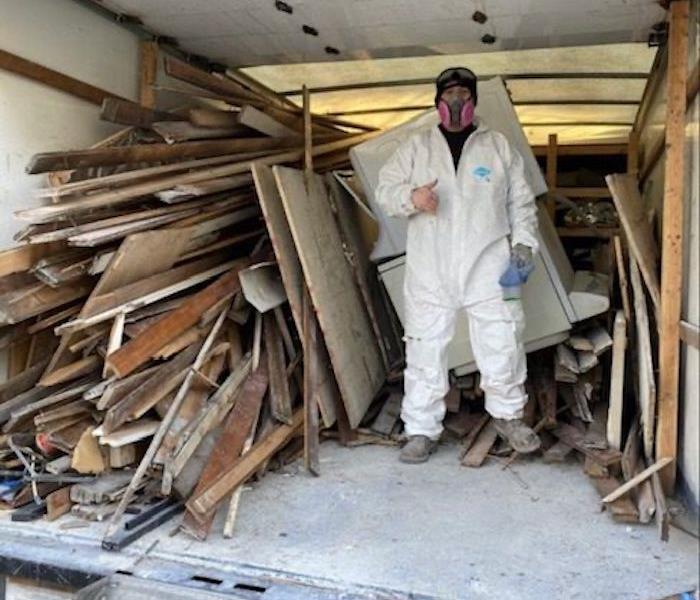 SERVPRO technician in truck with wood debris