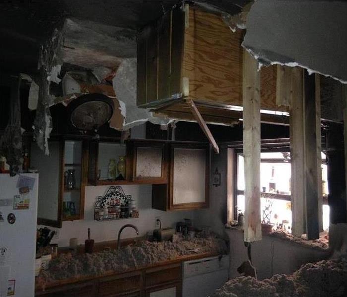 debris, wet and burnt on a kitchen count, hanging debris from ceiling
