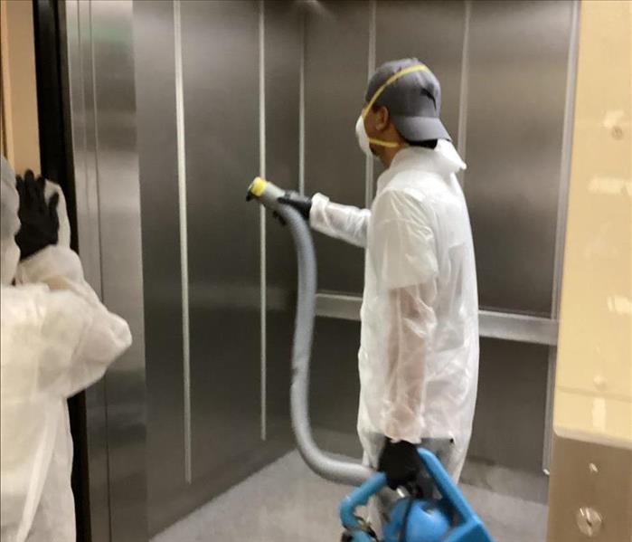 SERVPRO technician is sanitizing an elevator.